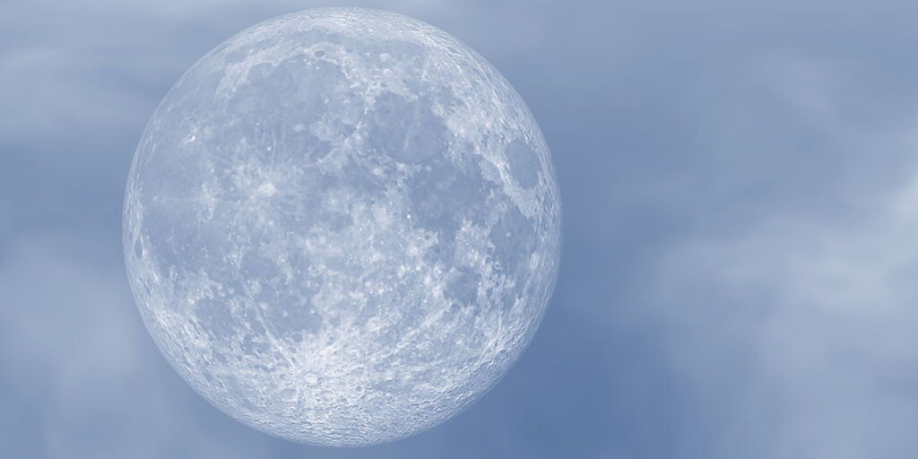 Vollmond vor grau-blauem leicht bewölkten Himmel