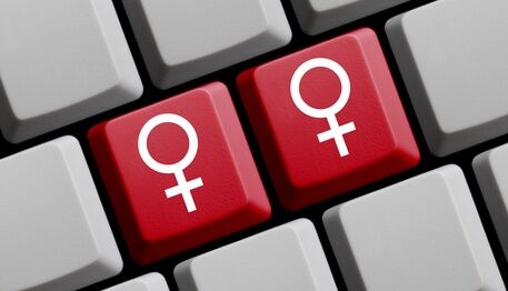 Ausschnitt aus Gender-Tastatur. Sichtbar sind zwei Computer-Tastaturtasten mit rotem Frauenzeichen, die anderen sichtbaren Tasten sind grau