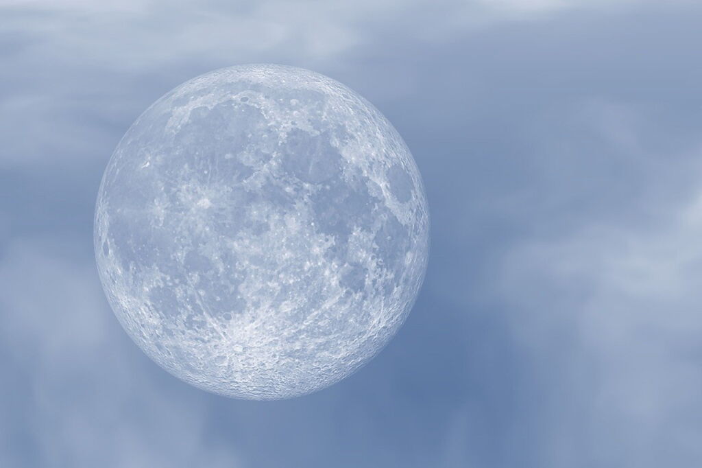 Vollmond vor grau-blauem leicht bewölkten Himmel