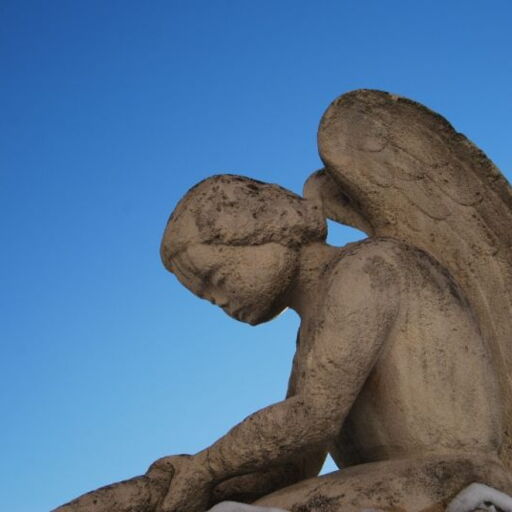 Ausschnitt Steinskulptur Engel vor blauem Himmel