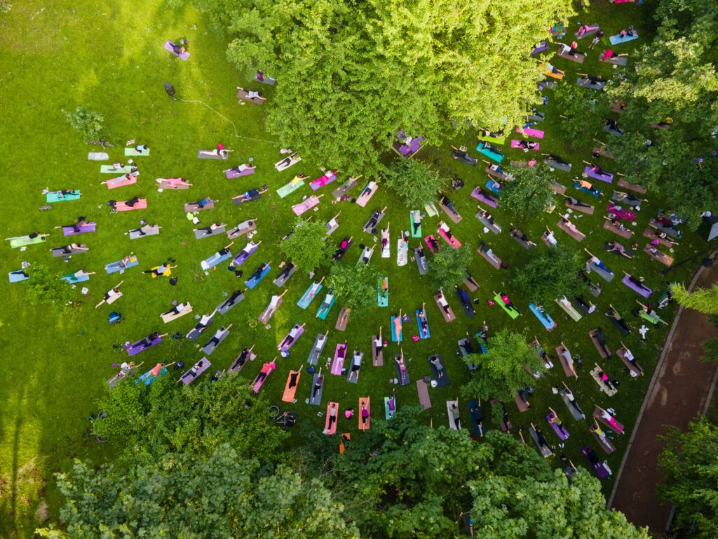 Overhead-Ansicht von Menschen, die im Park Yoga machen.